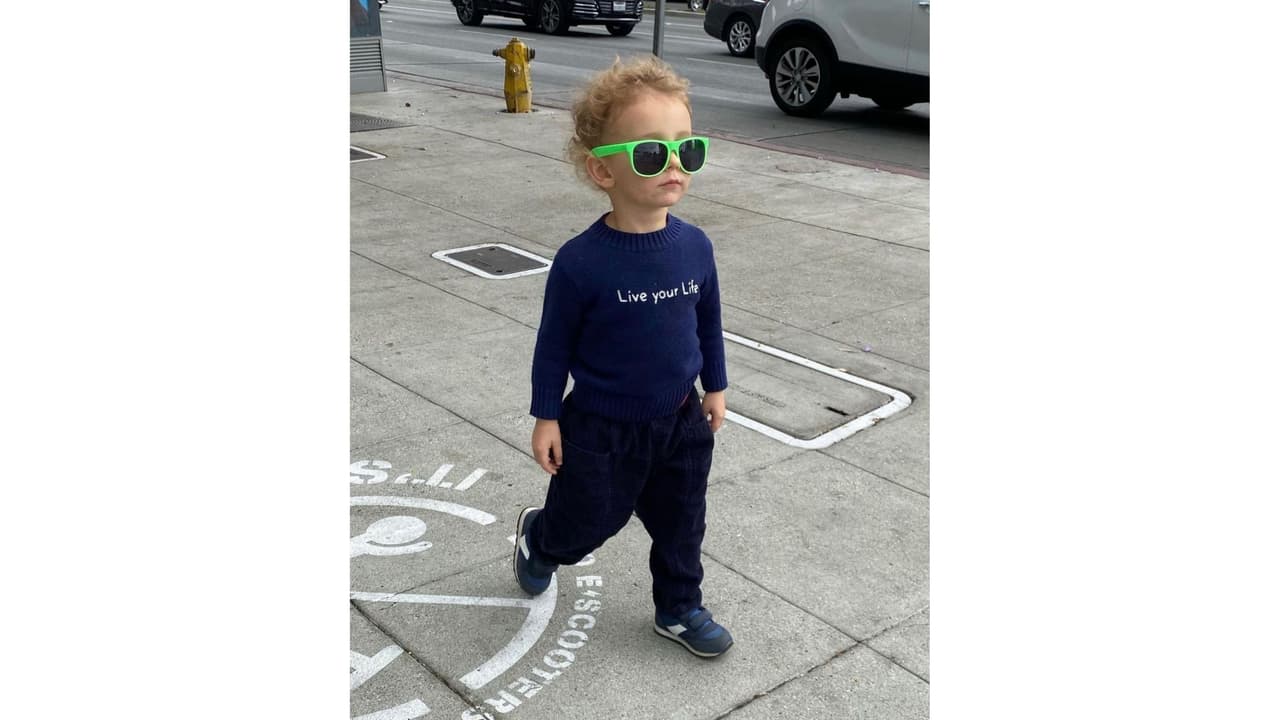 El hijo de la pareja usa un suéter con el nombre de la canción de su papá.