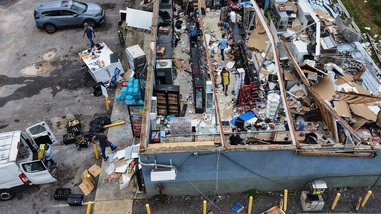Varias personas rescatan los objetos de su minimercado destruido tras el paso del huracán Isaias en Milton, Florida, el sábado 10 de octubre de 2026.