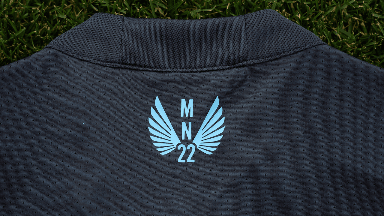La etiquesta "MN 22" en la parte trasera del cuello está presente en un color azul claro.
<br>