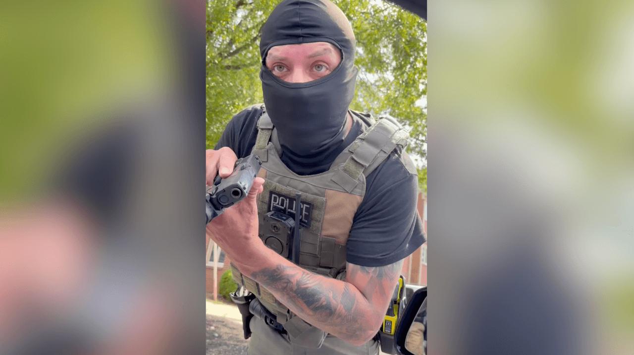 Un agente de ICE apunta con su arma a una ciudadana estadounidense que pregunta sobre un operativo