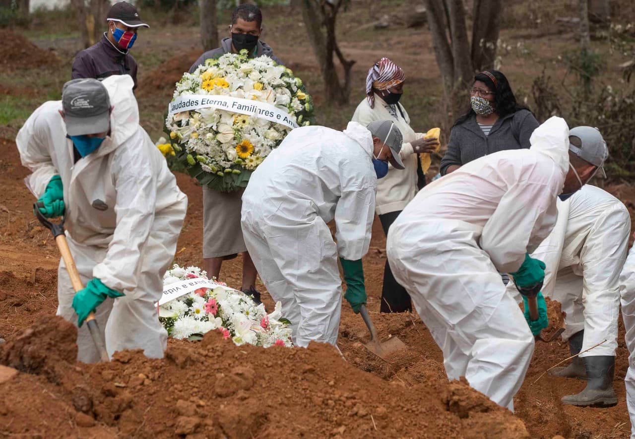 Familiares observan a trabajadores del cementerio palear tierra sobre el ataúd de Paulo Roberto da Silva, de 47 años, quien murió de COVID-19, en el cementerio de Sao Luiz en Sao Paulo, Brasil.
