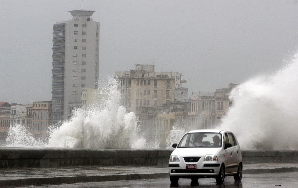 LA HABANA, CUBA: A car passes by the Havana's Malecon splashed by waves while the Hurricane Rita starts barrelling Cuba, 20 September 2005. Rita churned past along the Cuban coast at tropical storm strength and became a hurricane on Tuesday morning, packing sustained winds of 140 kilometers per hour (85 mph) with higher gusts. AFP PHOTO/Adalberto ROQUE (Photo credit should read ADALBERTO ROQUE/AFP/Getty Images)