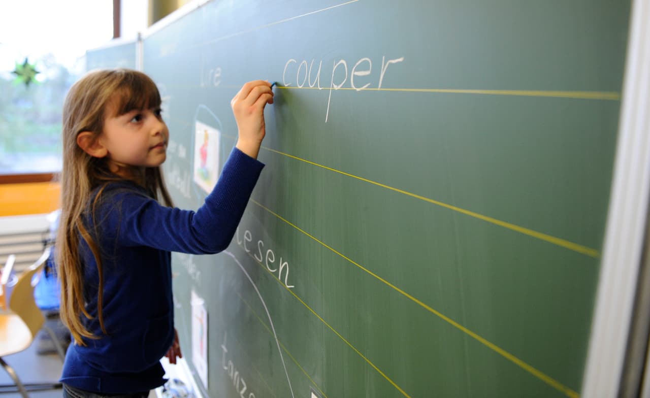 TO GO WITH AFP STORY BY ETIENNE BALMER A young girl of a German elementary school writes on a blackboard during a French lesson, on February 21, 2014, in Voelklingen, western Germany. French is called to be the second official language in the Saar region in 2043. AFP PHOTO / JEAN-CHRISTOPHE VERHAEGEN (Photo credit should read JEAN-CHRISTOPHE VERHAEGEN/AFP/Getty Images)