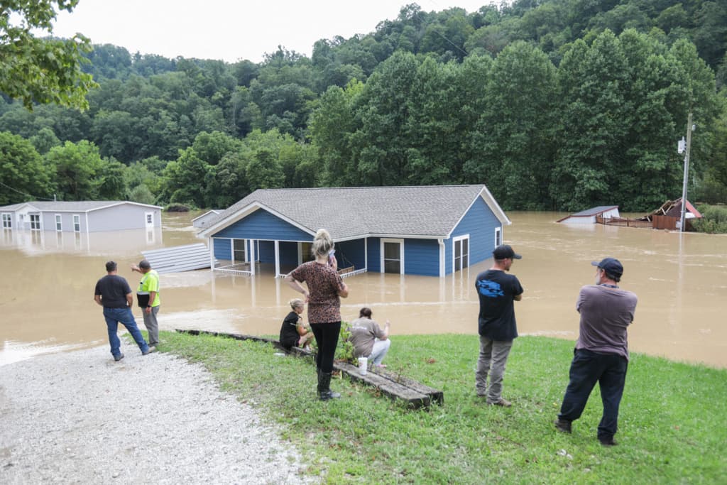 Una familia mira su casa sumergida bajo las aguas del río Kentucky en Jackson, Kentucky.