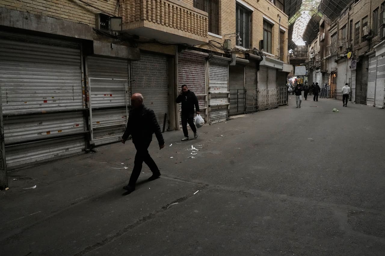La gente pasa por tiendas cerradas en el casi vacío bazar principal tradicional de Teherán, Irán, el martes 10 de marzo de 2026.