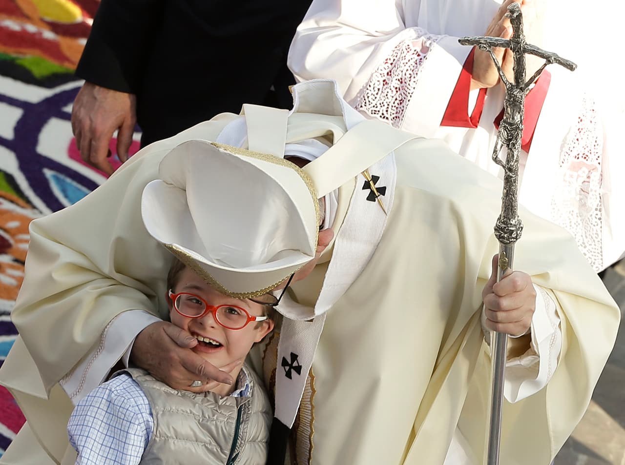 El Papa Francisco saluda y besa a un niño con síndrome de Down.