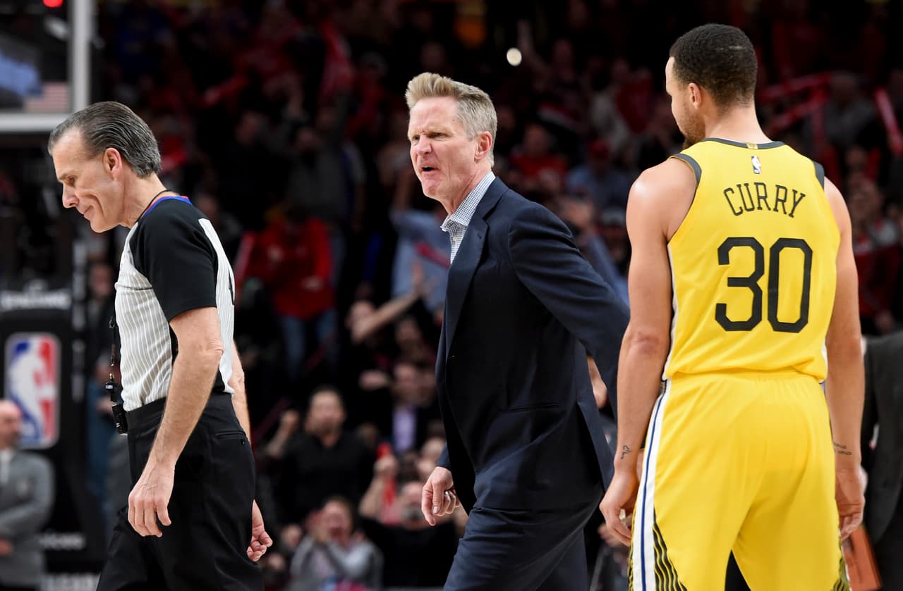 El coach de los Golden State Warriors, Steve Kerr, le grita al referee Ken Mauer, ante la mirada de Stephen Curry, en el juego donde los Blazers se impusieron 129-107 en Portland.