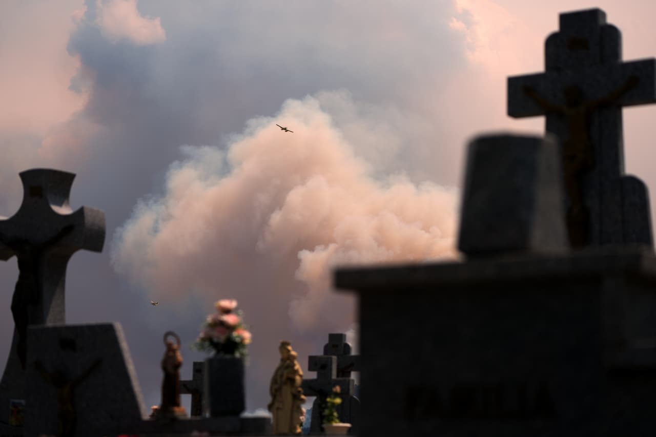 Una avioneta vuela por una estela de humo en El Tiemblo, Madrid.