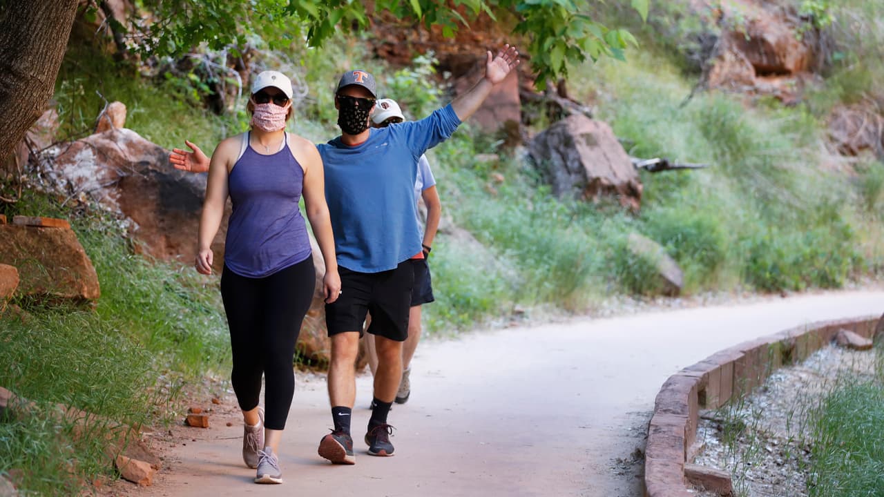 Turistas con máscaras visitan el parque nacional Zion en Springdale, Utah. La nueva camapaña busca que todos los habitantes de Utah sigan este ejemplo.