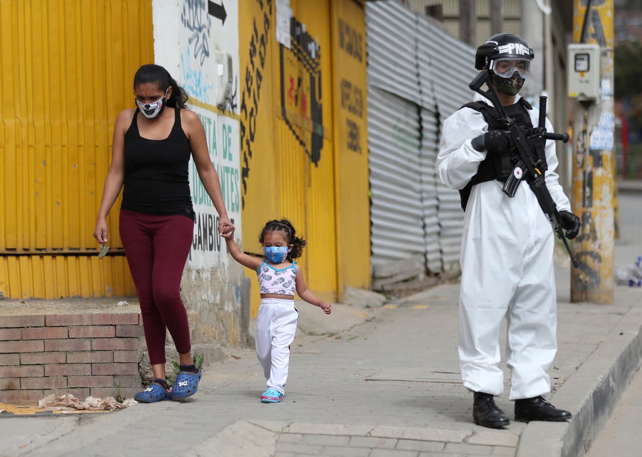 Un soldado con traje de protección y un arma hace guardia en Ciudad Bolívar, un área de Bogotá con gran número de casos.