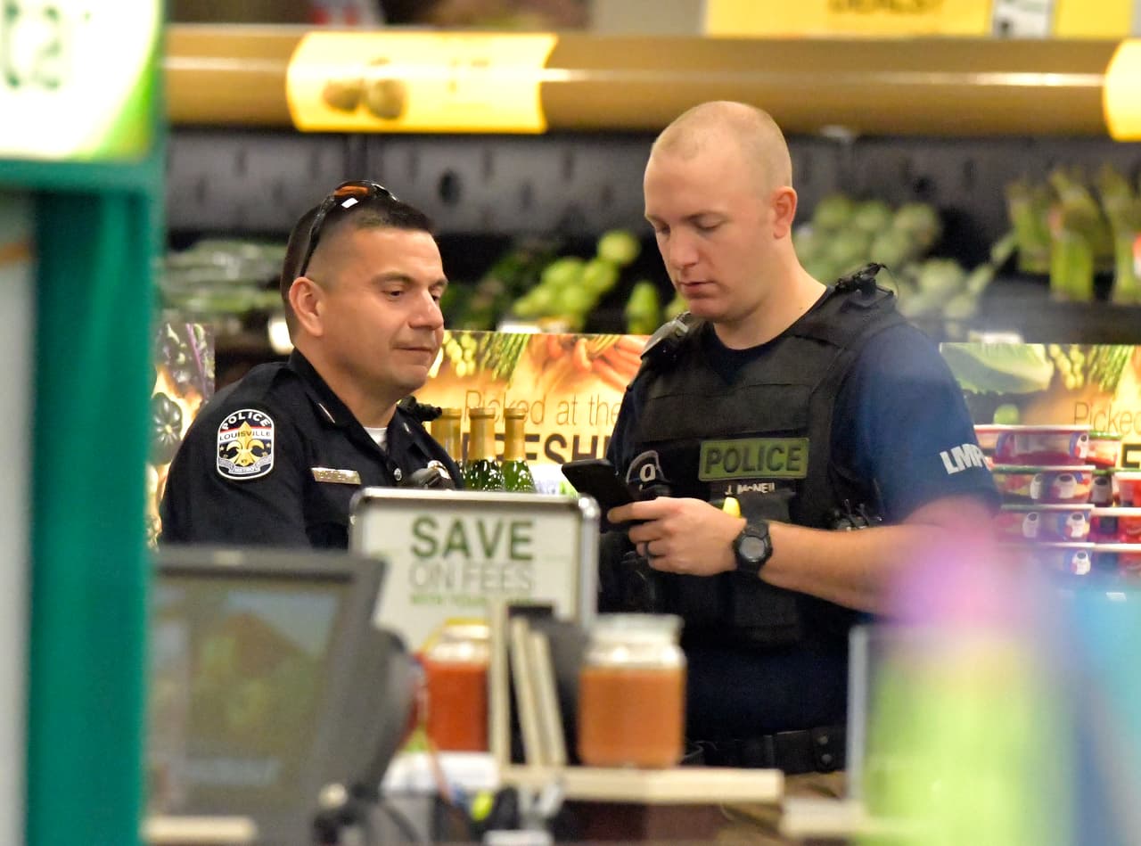 Agentes de la Policía de Louisville hablan al interior de una tienda Kroger en Jeffersontown, Kentucky, donde sucedió un tiroteo que dejó dos muertos.