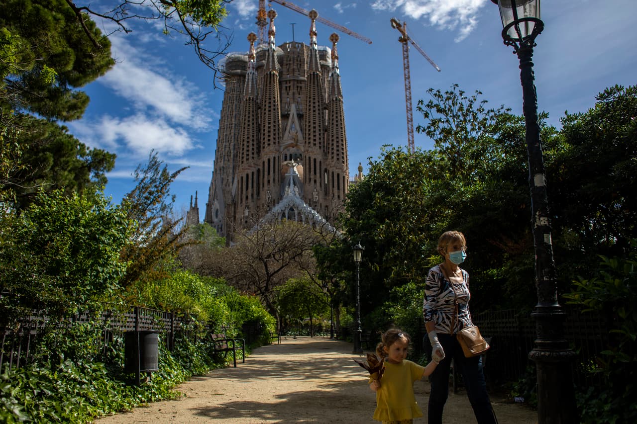 Una mujer camina con su nieta cerca de La Sagrada Familia en Barcelona.
