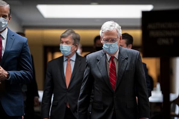 Senadores entrando a la sede del Capitolio con mascarillas.