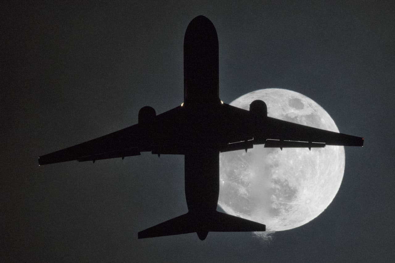 <b>Reino Unido. </b>Un avión vuela frente a una superluna. Fotografía capturada desde el aeropuerto Heathrow de Londres.