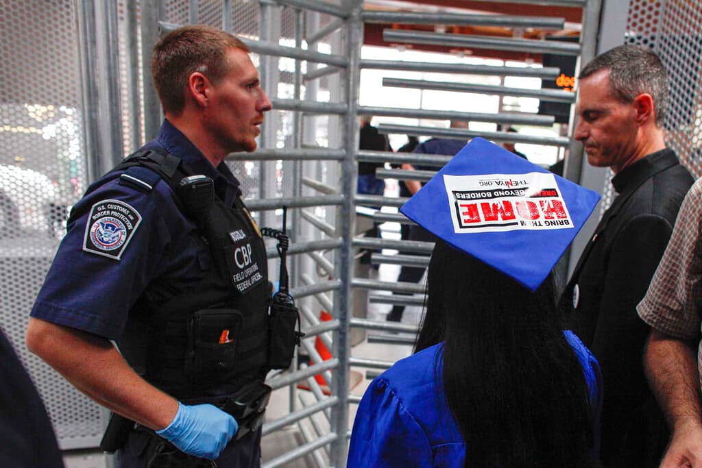 Una joven "Dreamer", vestida con toga y birrete de graduación, planea solicitar un permiso de permanencia temporal por razones humanitarias junto con otras personas. Posteriormente, las autoridades fronterizas de EE. UU. detuvieron a la joven y a sus acompañantes.