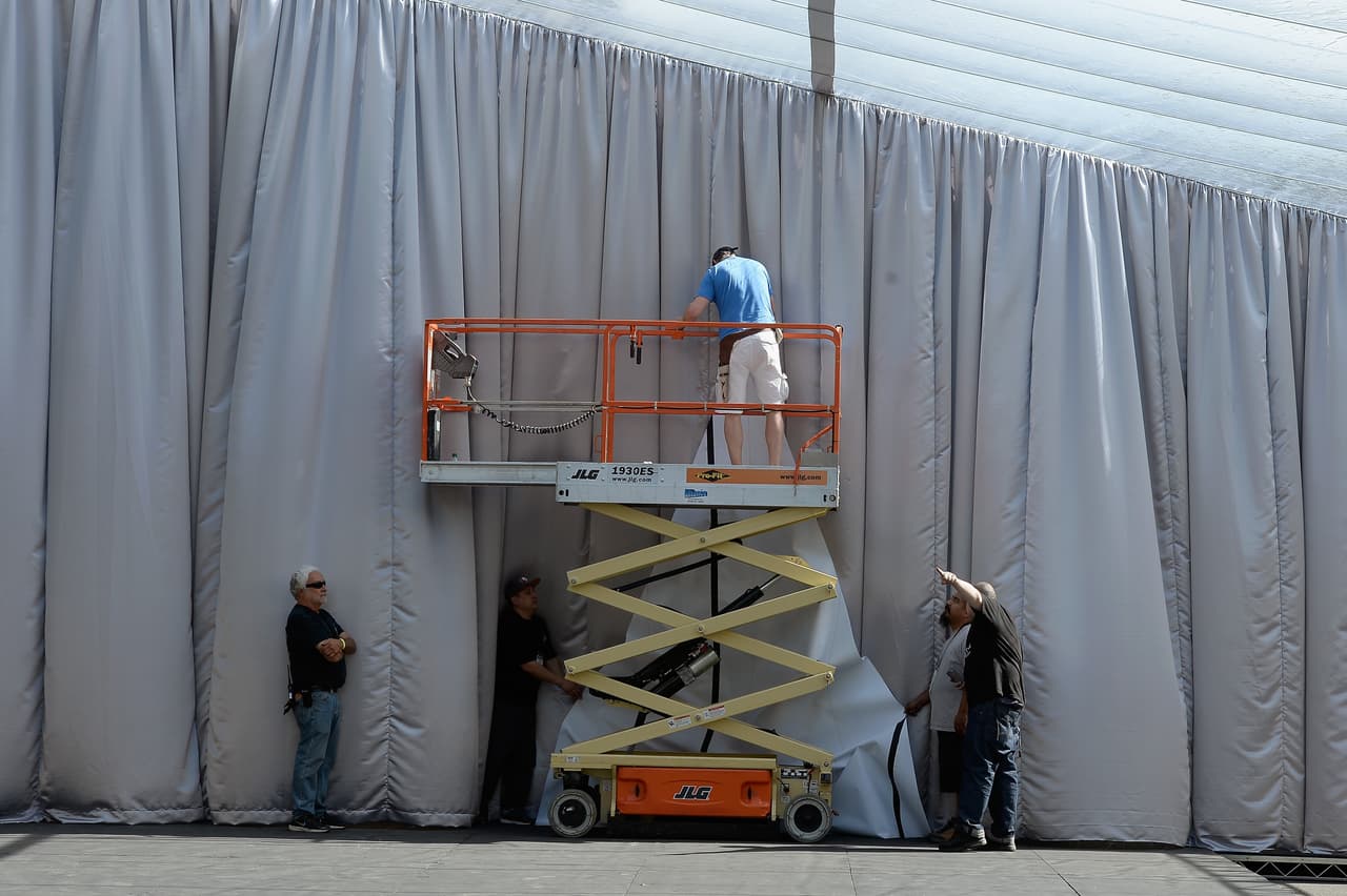 Obreros colocan las mantas y tarimas para la alfombra roja.