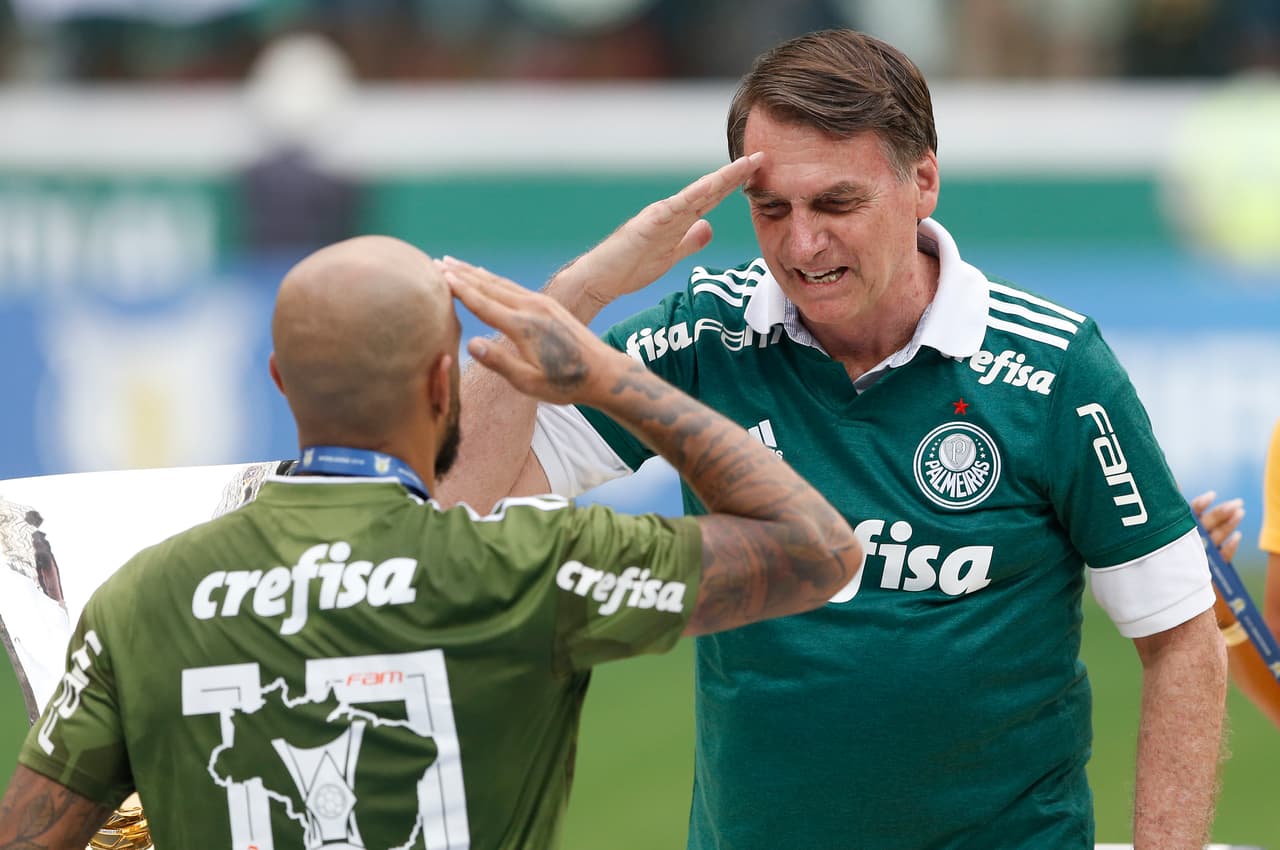 Jair Bolsonaro saluda al jugador del Palmeiras Felipe Melo en São Paulo, Brasil, el domingo 2 de diciembre de 2018 con una camiseta del Palmeiras. (Foto AP/Andre Penner)