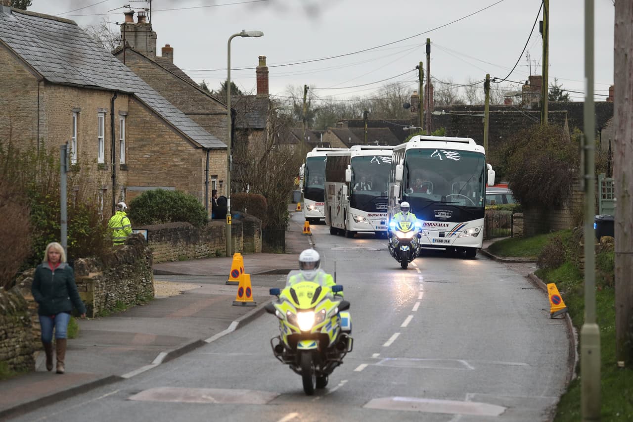 La policía escolta varios autobuses que abandonan la base de la RAF en Oxfordhire, Inglaterra.