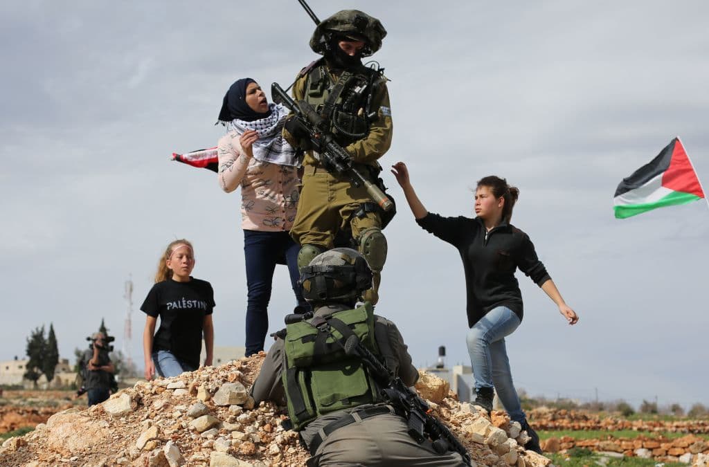 Palestinian Ahed Tamimi (L) and her mother Nariman (C) scuffle with Israeli security forces during clashes following a demonstration in the West Bank village of Nabi Saleh on February 6, 2015, to protest against the expansion of Jewish settlements on Palestinian land. / AFP PHOTO / ABBAS MOMANI (Photo credit should read ABBAS MOMANI/AFP/Getty Images)