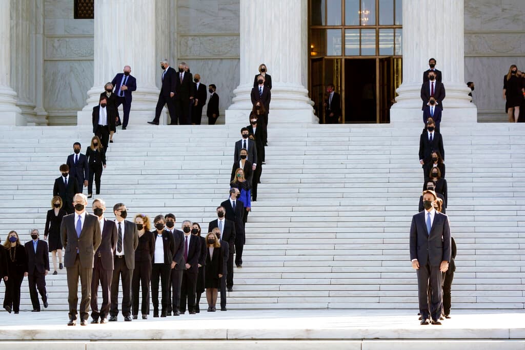 Exasistentes de la jueza Ruth Bader Ginsburg riden homenaje a su exjefa vestidos de negro y formando largas filas en las escalinatas de la Corte Suprema, el miércoles 23 de septiembre del 2020 en Washington. (AP Foto/J. Scott Applewhite)