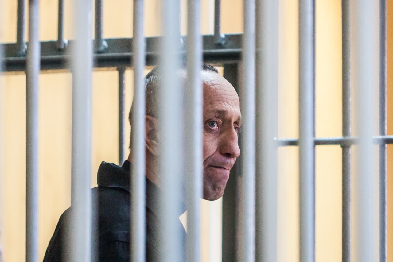 Serial killer Mikhail Popkov stands inside a defendants' cage during a court hearing in Irkutsk on December 10, 2018. - A Siberian policeman who raped and killed women after offering them late-night rides was found guilty of dozens more murders on December 10, 2018, making him Russia's most prolific serial killer of recent times. A court in the city of Irkutsk found Mikhail Popkov guilty of 56 murders between 1992 and 2007, sentencing him to a second life term. He was already in prison after being convicted of killing 22 women in 2015. (Photo by Anton KLIMOV / AFP) (Photo credit should read ANTON KLIMOV/AFP/Getty Images)