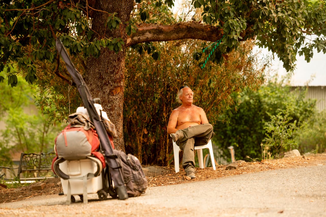 Clay Brasil espera que lo lleven a una estación de Amtrak
<b>mientras el incendio de Creek se acerca a la comunidad de North Fork en el condado de Madera, California.</b>
<br>