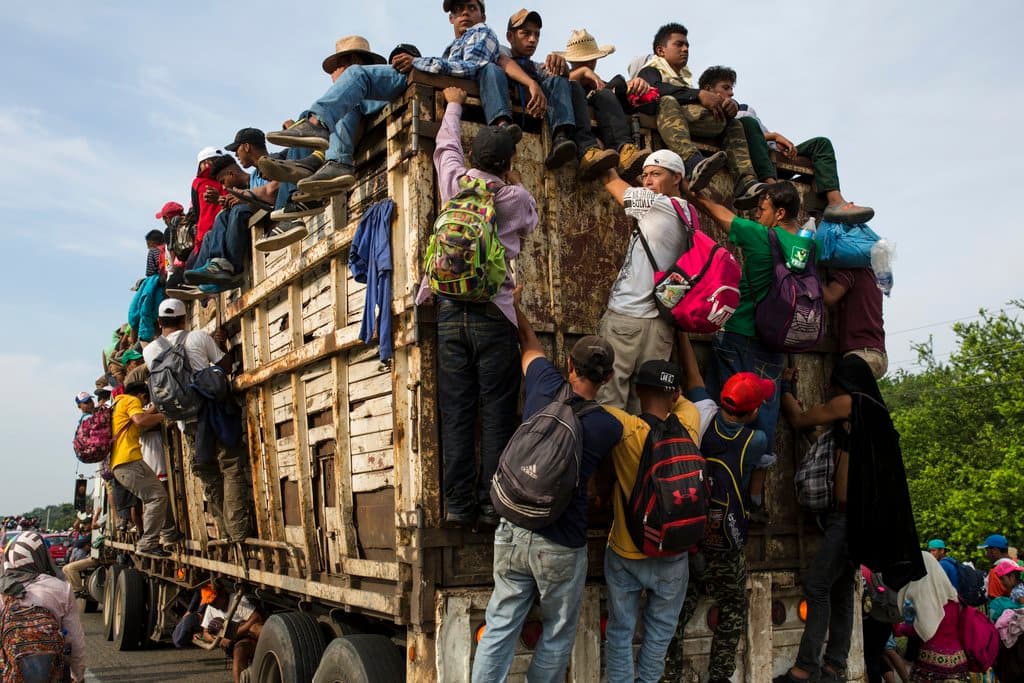 Migrantes en una caravana de centroamericanos que se dirigen a Estados Unidos abordan un camión en las afueras de Arriaga, 27 de octubre de 2018. (AP Foto/Rodrigo Abd)