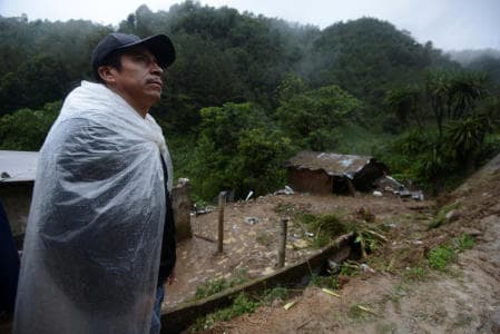 A residents stands near a house where a mudslide killed three people in Veracruz, Mexico after the passage of Earl