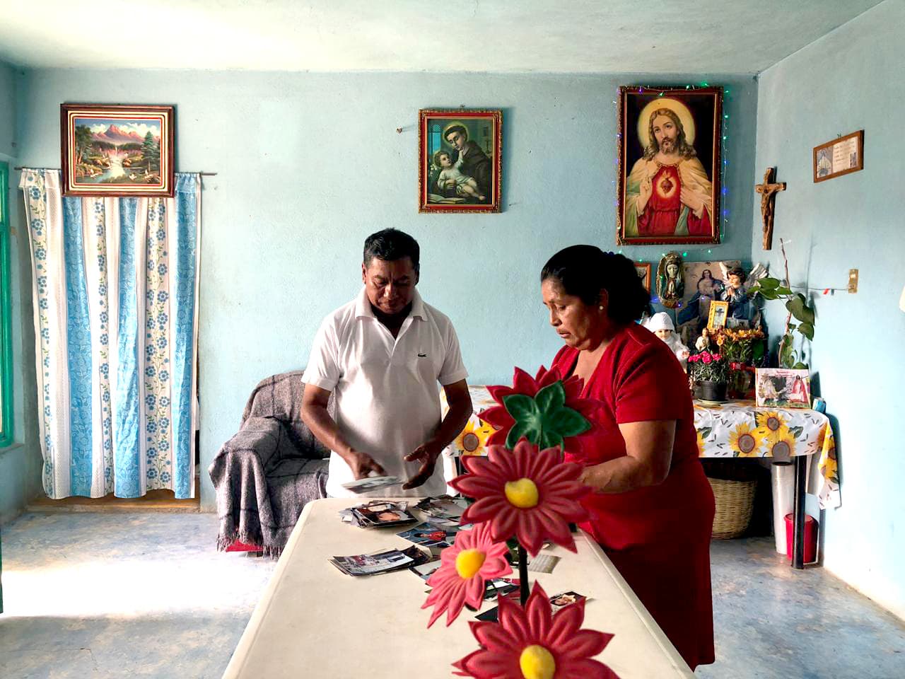 Los padres de Adela García revisan fotografías de su hija en su casa en San Simón Yehualtepec, en Puebla, México.