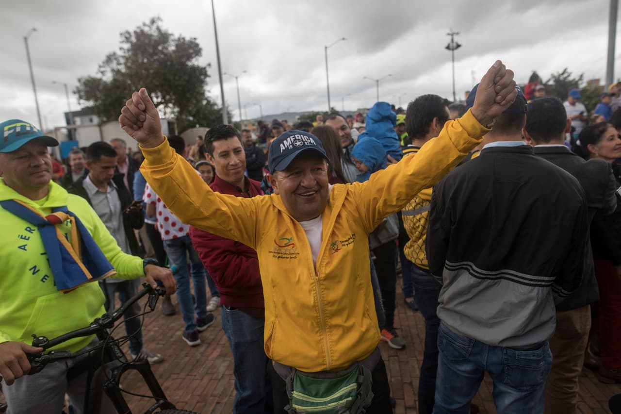 Fabio Rodríguez, el primer entrenador de ciclismo de Egan celebra la victoria virtual de su antiguo alumno junto a otros habitantes del pueblo.