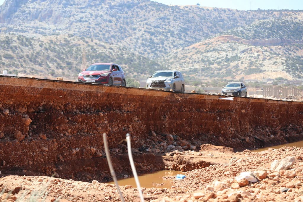 Los automóviles viajan por una carretera dañada por las recientes inundaciones el 15 de septiembre de 2023 en Soussah, Libia.