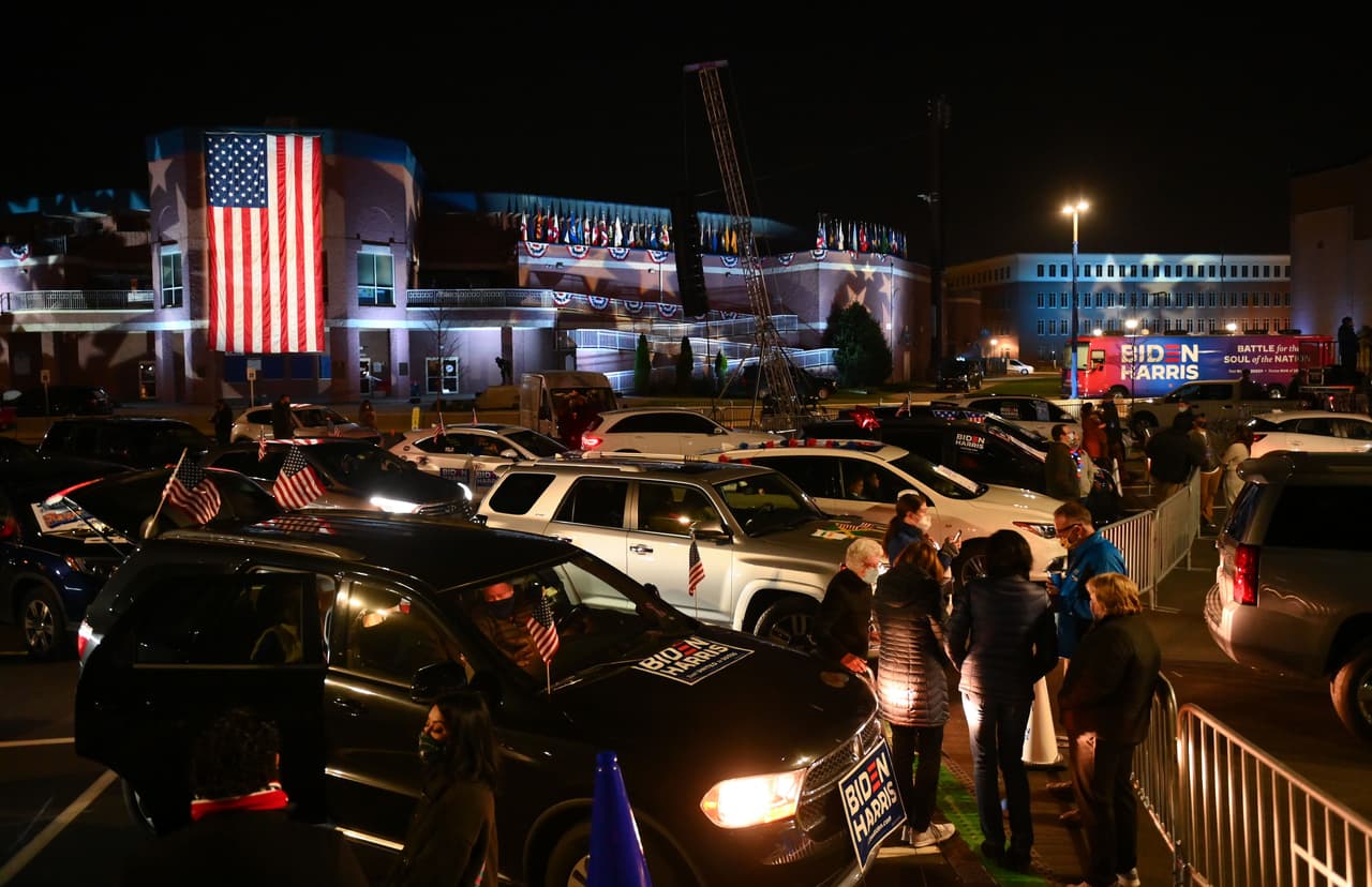 Supporters of Democratic presidential nominee and former Vice President Joe Biden check their phones for partial election results outside the Chase Center in Wilmington, Delaware on November 3, 2020. (Photo by ANGELA WEISS / AFP) (Photo by ANGELA WEISS/AFP via Getty Images)