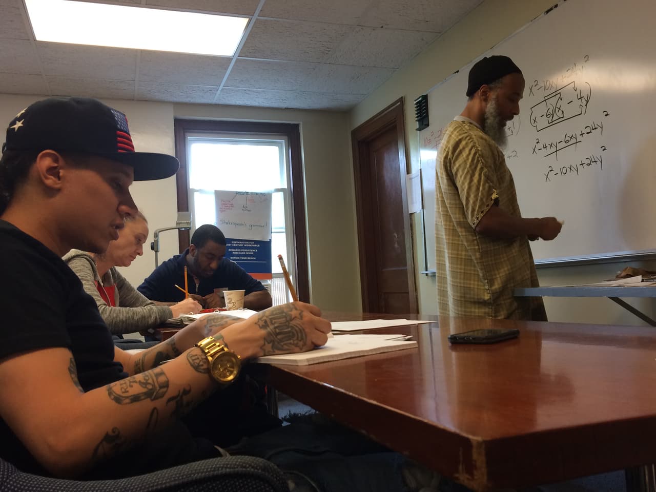 Alex Diaz, participante en Boston Uncornered, toma notas durante una clase de matemáticas impartida por el instructor de College Bound Dorchester, Ismail Abdurrashid.