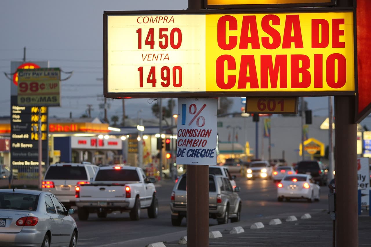 Una casa de cambio del pueblo fronterizo de Calexico, en California, promociona la tasa del día 12 de marzo de 2009. Para aquel momento, esa zona limítrofe de mayoría hispana registraba una de las tasas de desempleo más altas del país (22.6%), comparable con las de los tiempos de la Gran Depresión. La población latina era la comunidad más afectada por esta crisis, donde se combinaba la sequía que afectaba los cultivos; el desplome del peso mexicano, que afectaba la capacidad de compra de los mexicanos que cruzaban la frontera; y la crisis general del estado, que obligó a una subida de impuestos y a recortes en los programas sociales que atendían a la comunidad. (David McNew)