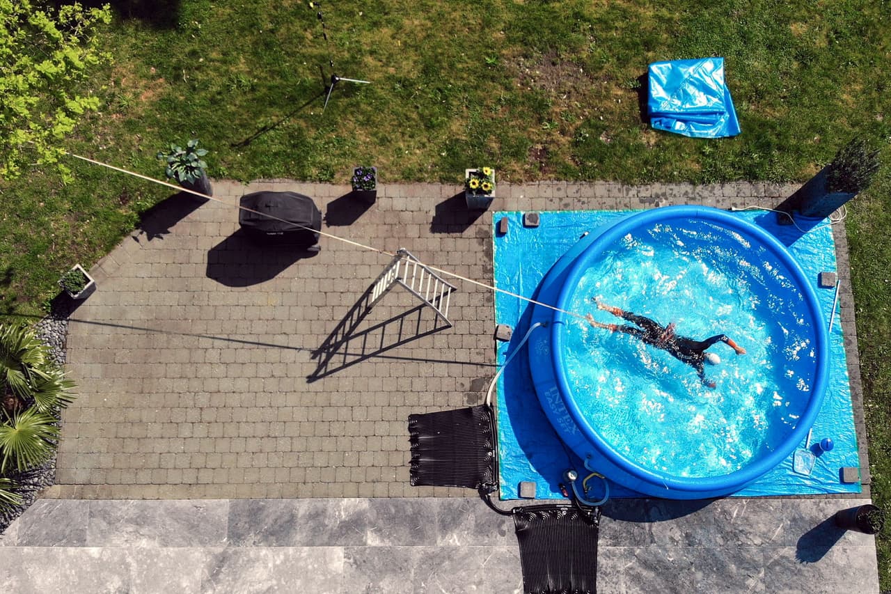 El triatleta belga Jelle Geens se ejercita en una piscina inflable en Heusden-Zolder, Bélgica. Ese país mantiene medidas de aislamiento desde hace más de dos meses. 4 de mayo.
<br>