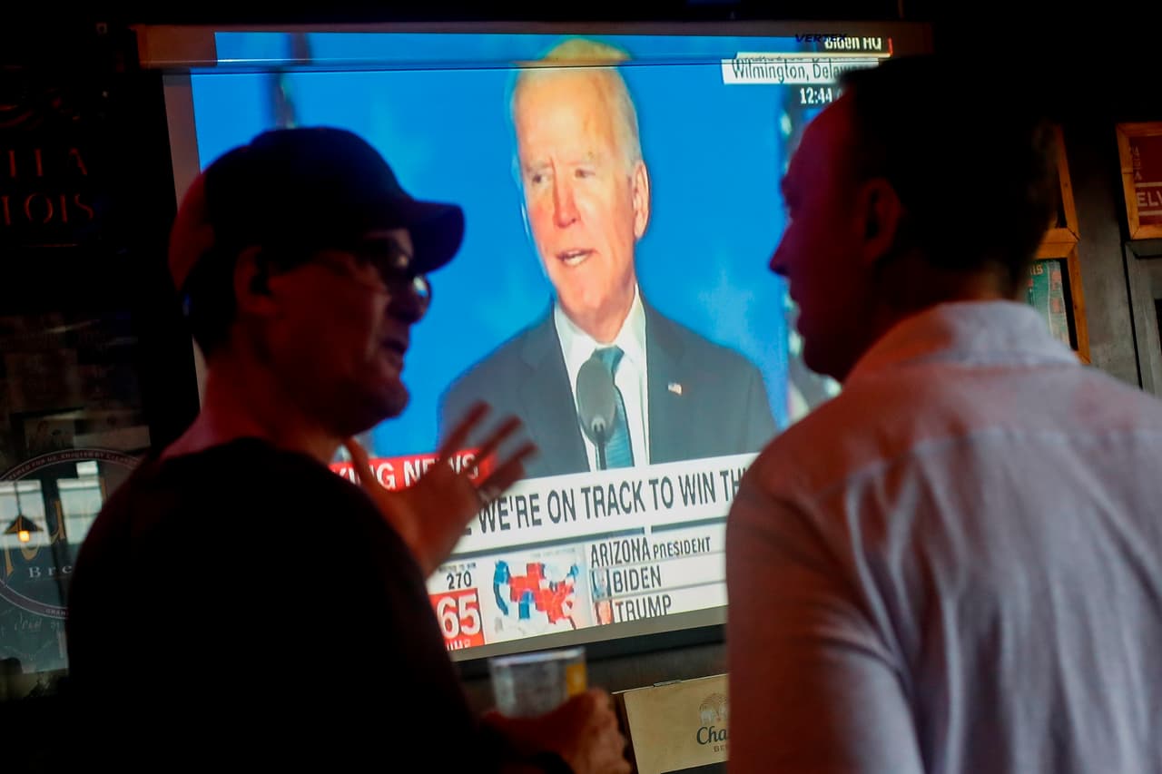 La insistencia infundada de Trump de la existencia de una ‘trampa’ aviva la preocupación de que la resolución definitiva tarme mucho más. En la fotografía un grupo de partidarios de Biden escucha su discurso de la noche electoral desde Bangkok, Tailandia.