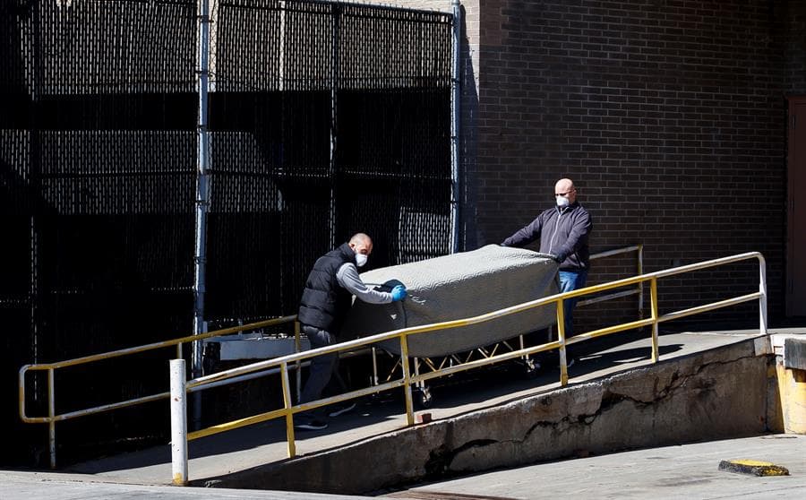 Empleados de una funeraria transportan una camilla a las afueras del Centro Médico Wyckoff Heights en Brooklyn, Nueva York.
<br>