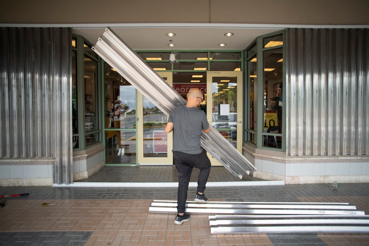 Un hombre protege las ventanas de un edificio en Humacao, en el extremo oriental de Puerto Rico.