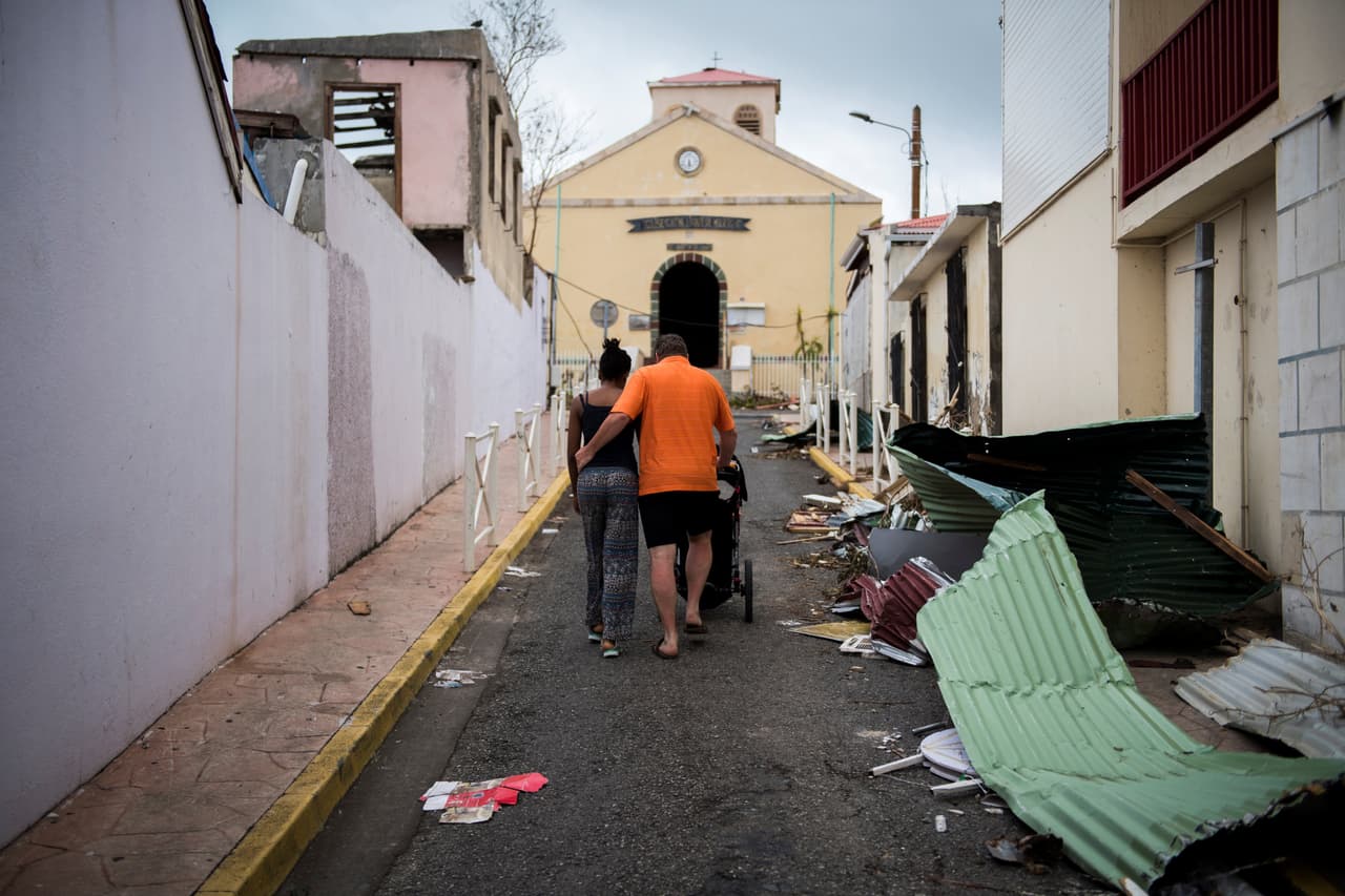 Una familia camina por los escombros de una calle en Marigot, Saint Martin, el sábado 9 de septiembre.