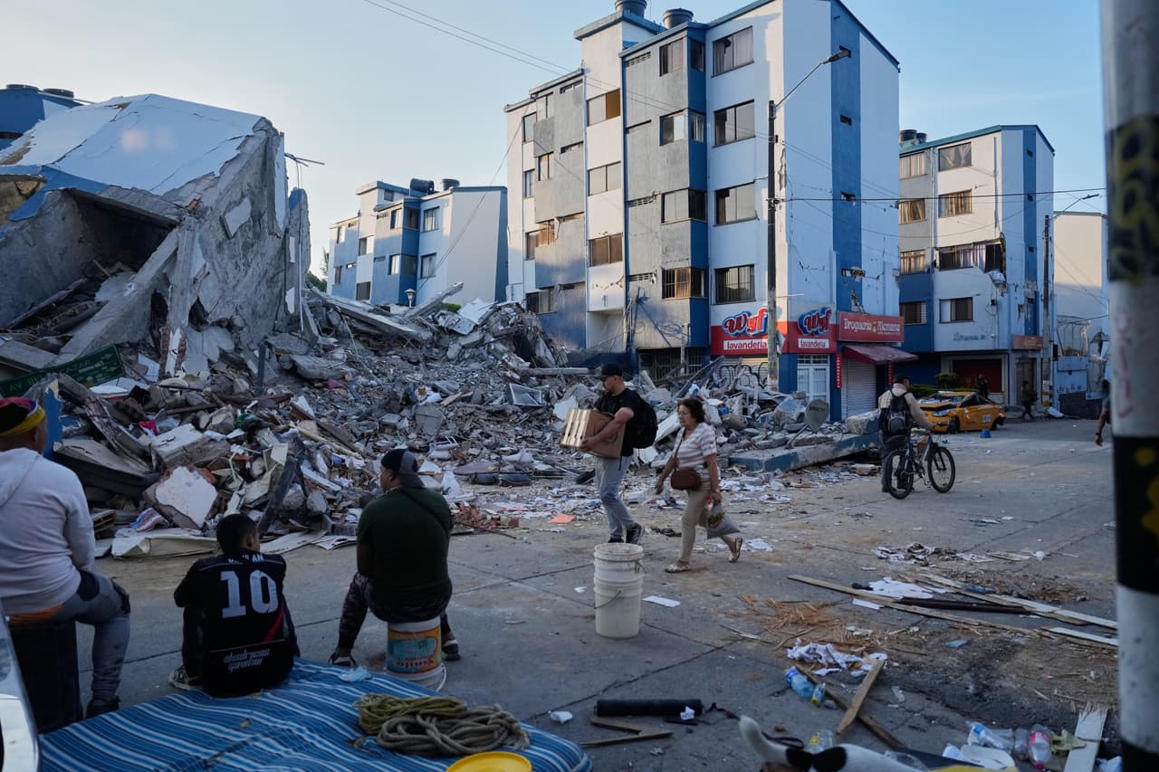 Varias personas pasan junto a un edificio derrumbado al día siguiente del terremoto que azotó Pereira, Colombia, el martes 11 de agosto de 2026. (AP Foto/Fernando Vergara)
