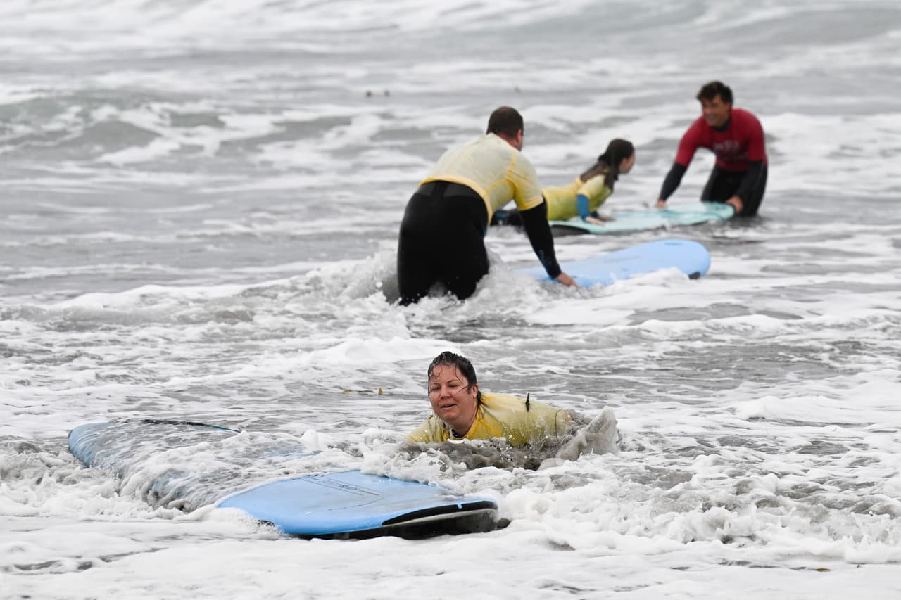 Una mujer que tomaba clases de surf en la escuela San Diego Surf es sacada a rastras de su tabla en San Diego el domingo 11 de octubre de 2026.