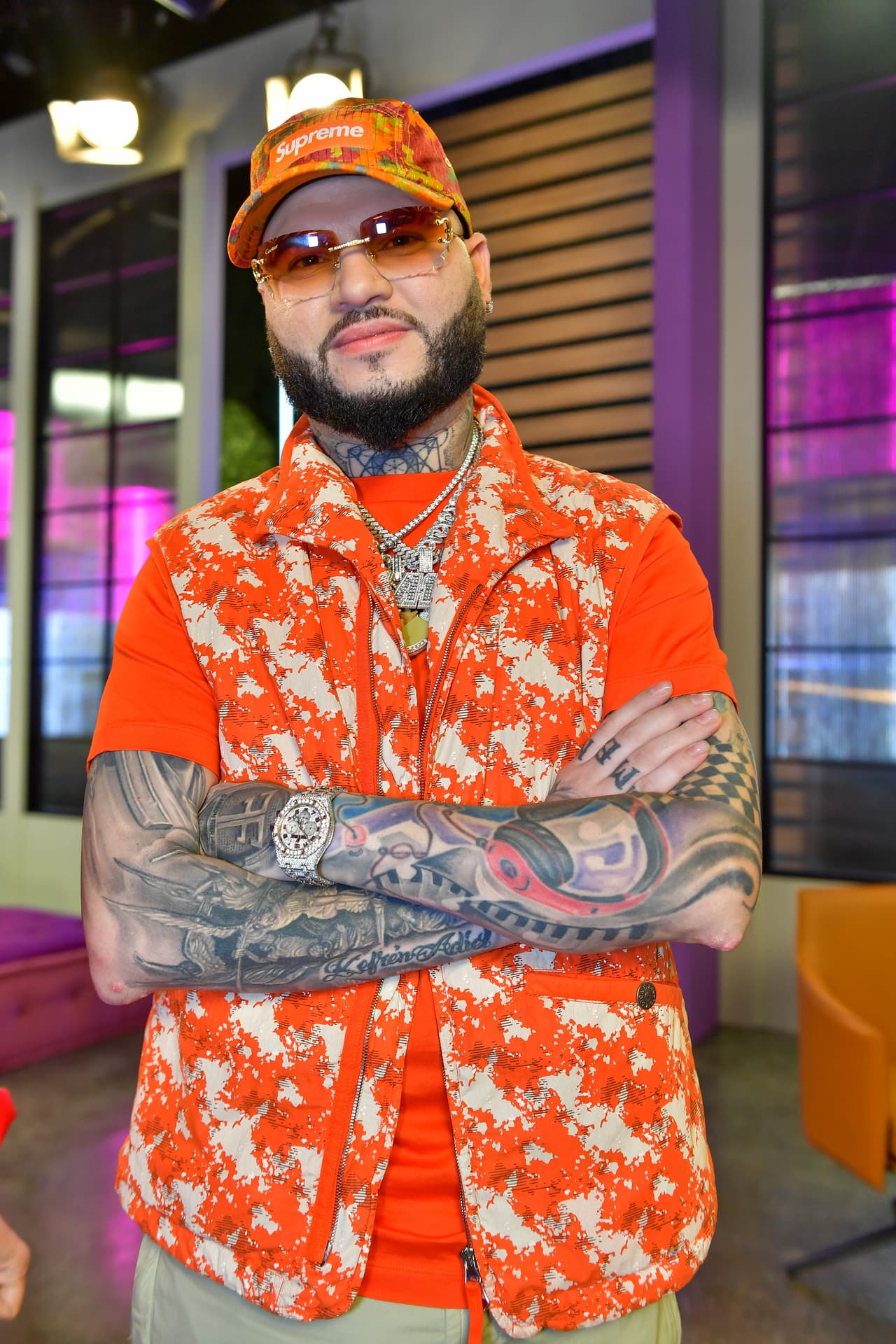 Farruko fue nuestro invitado de lujo y se presentó muy a su estilo, con una combinación de una gorra, playera y chaleco naranjas, con diferentes adornos para dar variedad a las prendas. Además de sus clásicas gafas y cadenas en el cuello.
