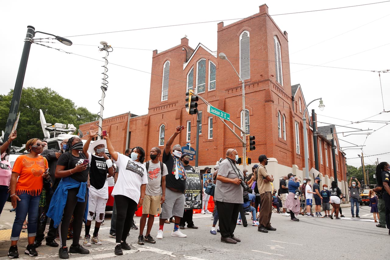 Dolientes de John Lewis reunidos fuera de la Iglesia Bautista Ebenezer. El congresista calificó a Trump de "ilegítimo" por considerar que había sido elegido gracias a la interferencia de Rusia (aunque no existe evidencia de que hubiera habido alguna alteración de votos en 2016).