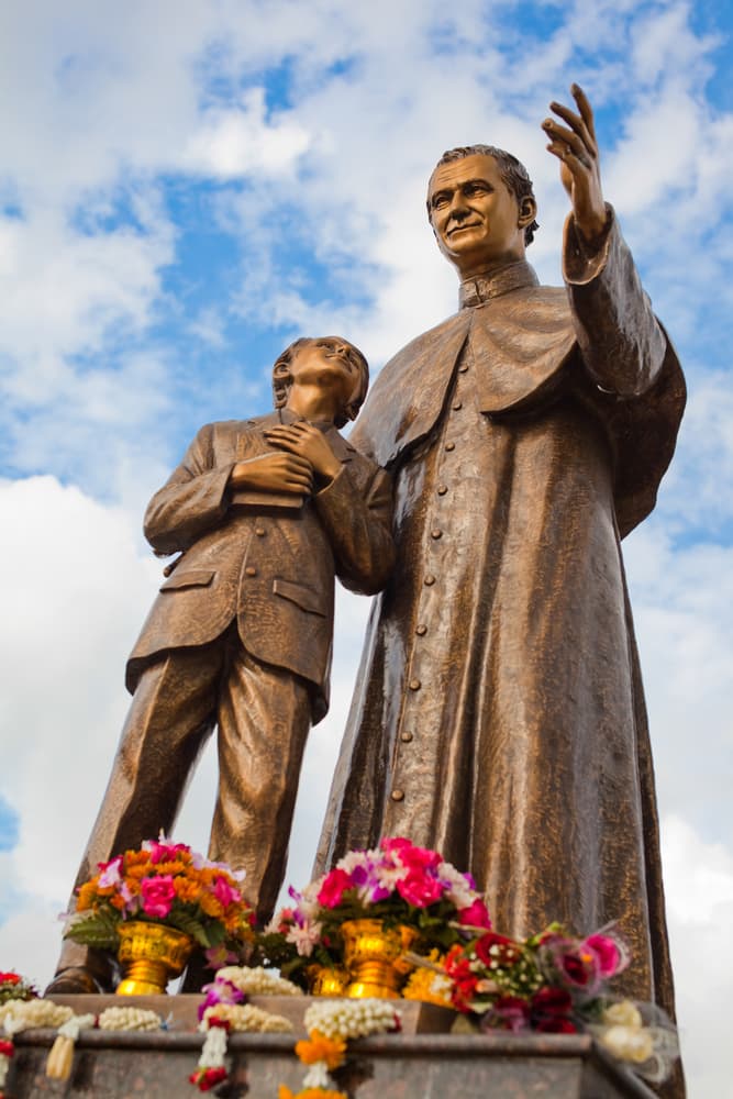 Se le han erigido varias estatuas, como patrono del deporte y sobre todo de la educación. Aquí San Juan Bosco, Patrón de los Futbolistas, ante la mirada de un joven.