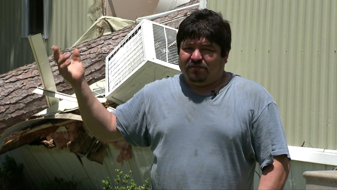 Alfonso Hernández, residente de Tomball, Texas, enseña los daños causados a su casa móvil, tras la caída de un árbol durante el paso de un tornado categoría F-0.