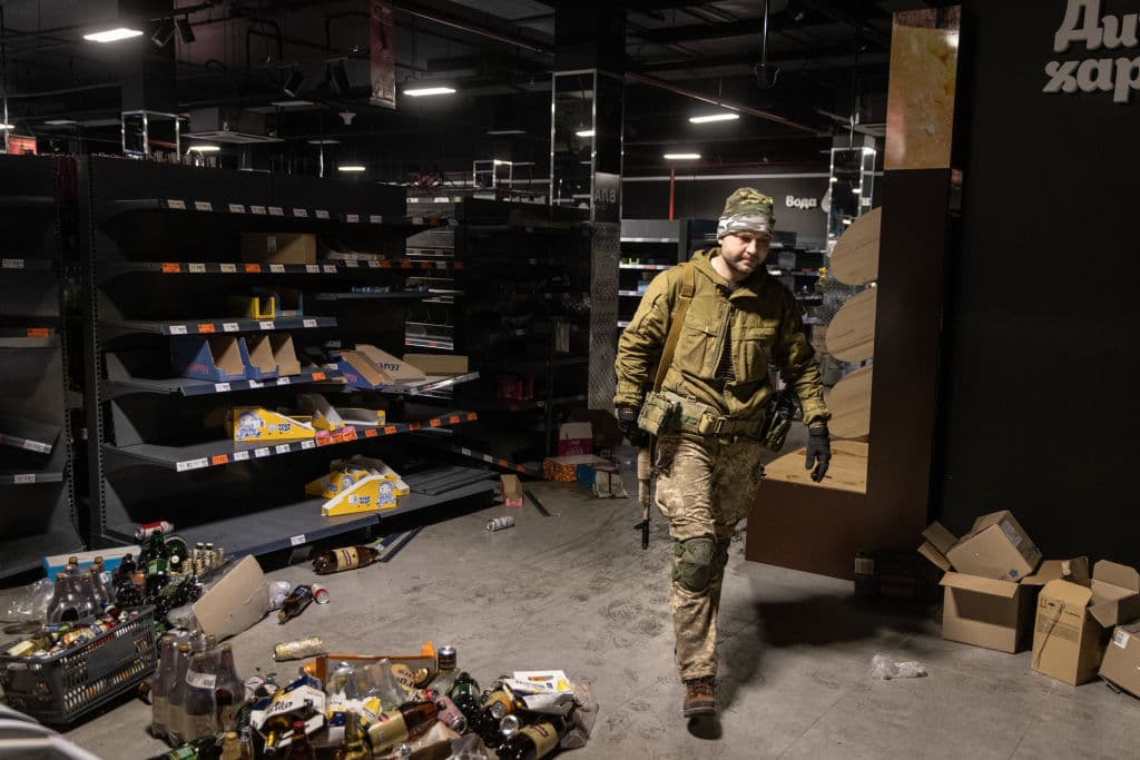 Un miembro del ejército ucraniano pasa junto a estantes vacíos para recolectar alimentos y otros artículos de una tienda de comestibles para distribuirlos a los residentes locales de Irpin.