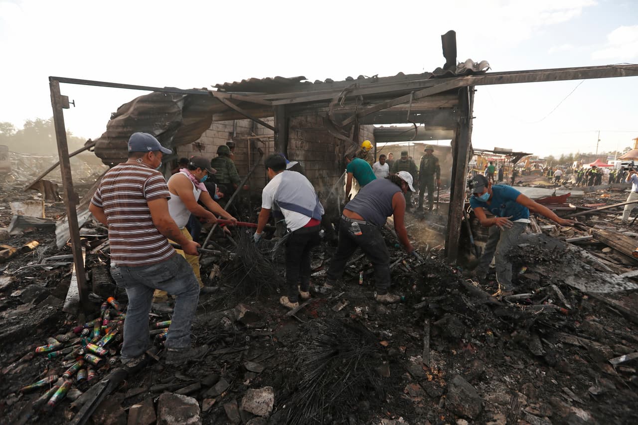 Residentes y rescatistas remueven los restos dejados por el estallido.