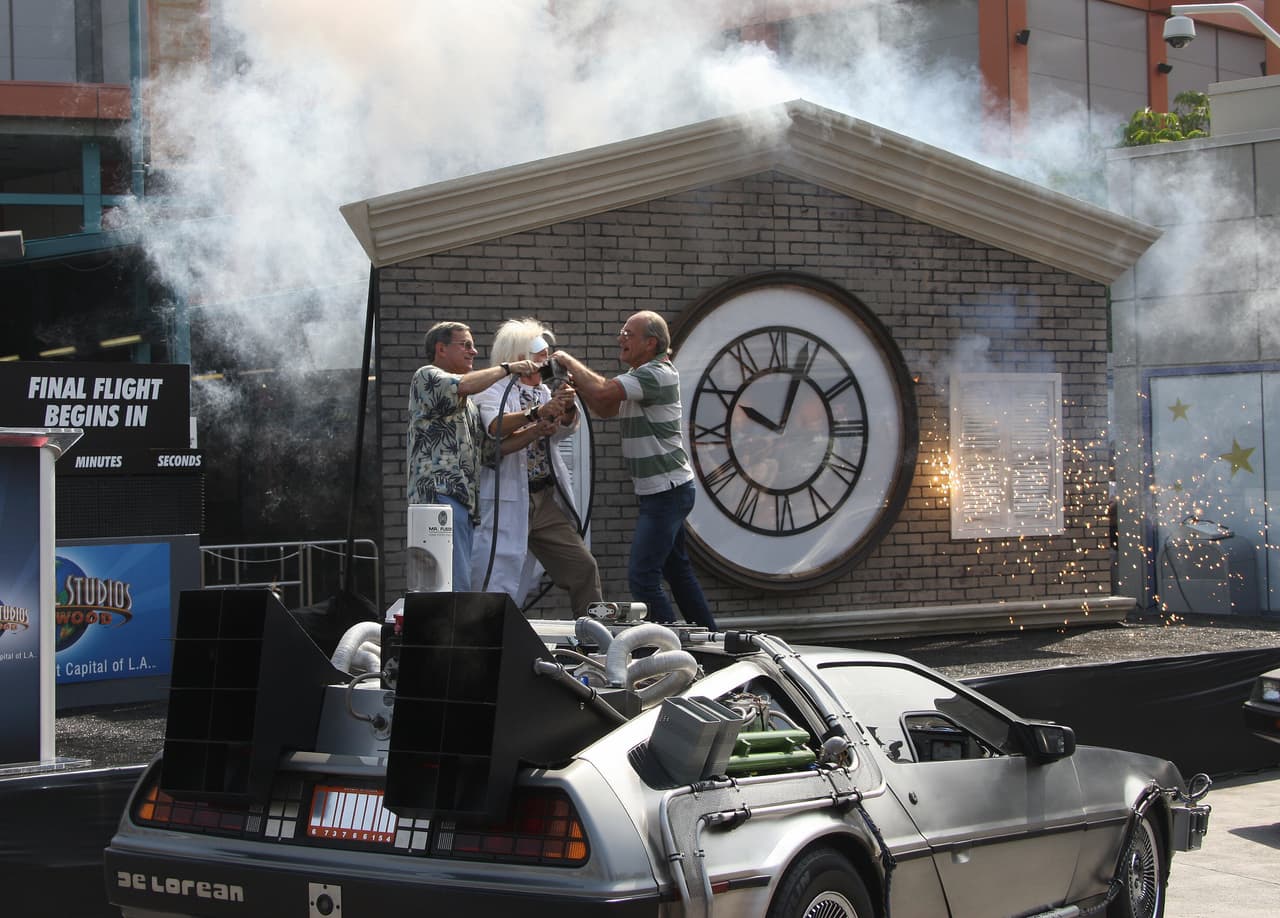 El actor Christopher Lloyd (derecha) y el escritor Bob Gale (izquierda), que escribieron y crearon la película "Regreso al futuro", participan con un actor que interpreta al personaje de Doc Brown (centro) en una ceremonia lúdica en Universal Studios Hollywood en University City, California, el 2 de agosto de 2007.