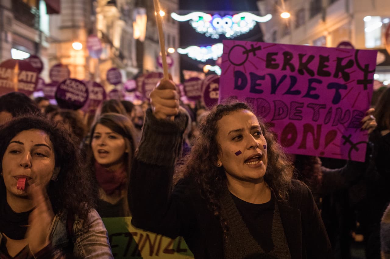 Las mujeres corean lemas y señales con la mano mientras marchan por la famosa calle Istiklal de Estambul.