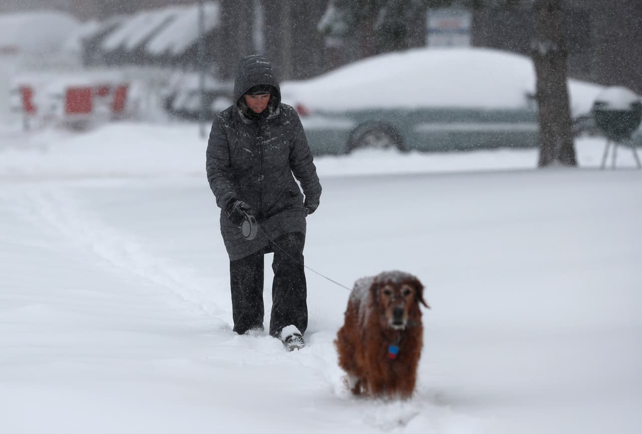 En la imagen, Pam Semmler camina junto a su perra Summit entre la nieve en Denver, Colorado, donde este martes no hubo clases debido al mal tiempo y tiendas, comercios y oficinas públicas tuvieron que cerrar sus puertas.